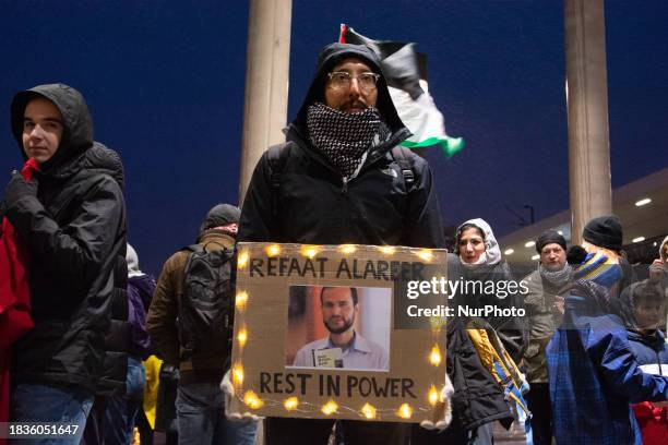 Photo of the renowned Palestinian poet Refaat Alareer, who was killed, is being displayed while about a hundred people are protesting for a ceasefire...