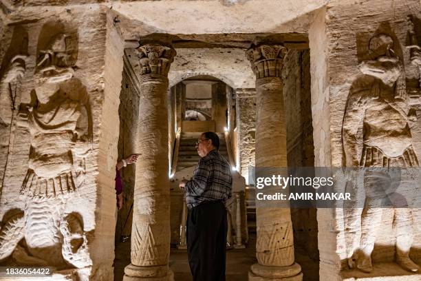 Reliefs of the ancient Egyptian funerary deity Anubis are pictured as a visitor is instructed by a guide at the ancient catacomb necropolis of Kom...