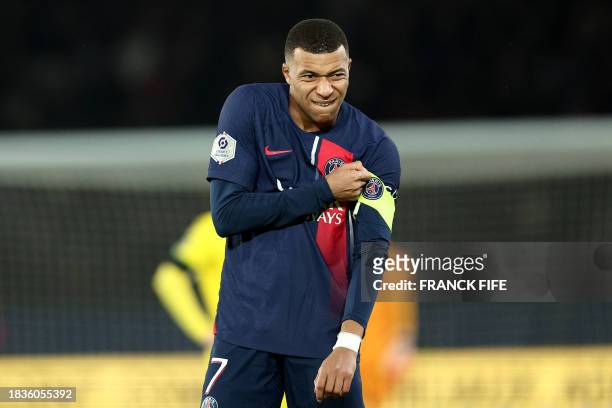 Paris Saint-Germain's French forward Kylian Mbappe puts on the captain armband during the French L1 football match between Paris Saint-Germain and...