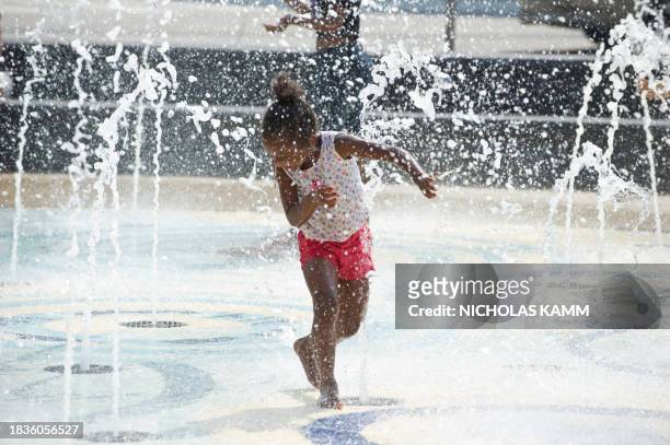 Girl plays in a fountain in Washington on July 22, 2011 as temperatures soar to over 100 degrees Fahrenheit . The US capital could again swelter...