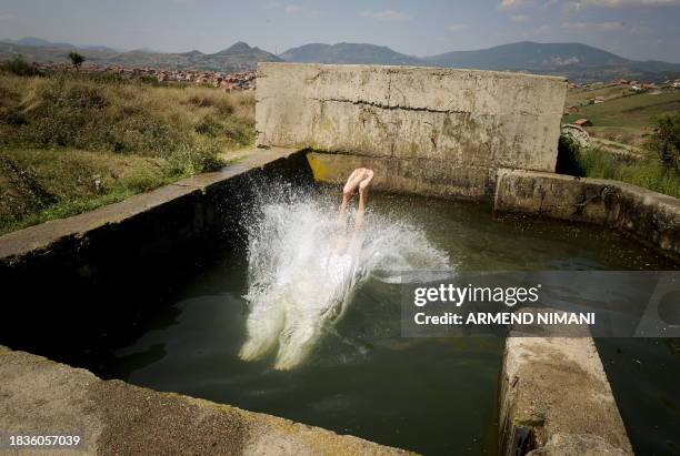 Kosovo Albanian youth dives into the water at the irrigation canal near the Kosovo divided town of Mitrovica on August 03, 2009. AFP PHOTO/ARMEND...