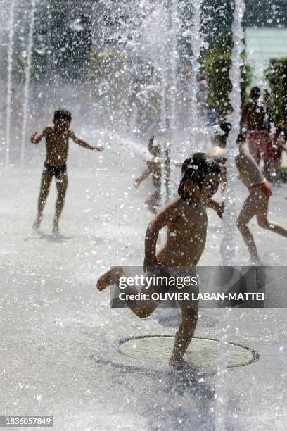 Children play in a fountain at the Parc Andre Citroen 02 July 2006 in Paris. According to Meteo France temperatures will rise from 05 July 2006 in...