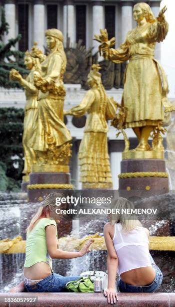 Two girls chat, as temperatures soared over 30 degrees Celsius, beside a fountain representative of the friendship of nations of the former Soviet...