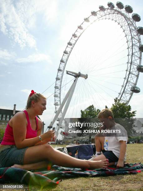 Gemma Godson and her nephew David enjoy a picnic under the London eye during a heat wave in London, 05 August 2003. Britain is suffering through a...