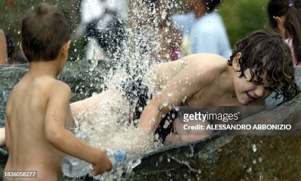 Boys play in a water fountain in London's Hyde Park, 10 August, as temperatures reached a new record of 37,9 degree centigrade at London's Heathrow...