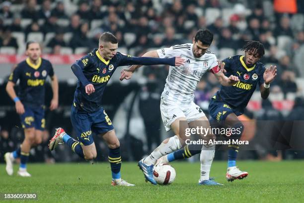 Necip Uysal of Besiktas is challenged by Fred and Sebastian Szymanski of Fenerbahce during the Turkish Super League match between Besiktas and...