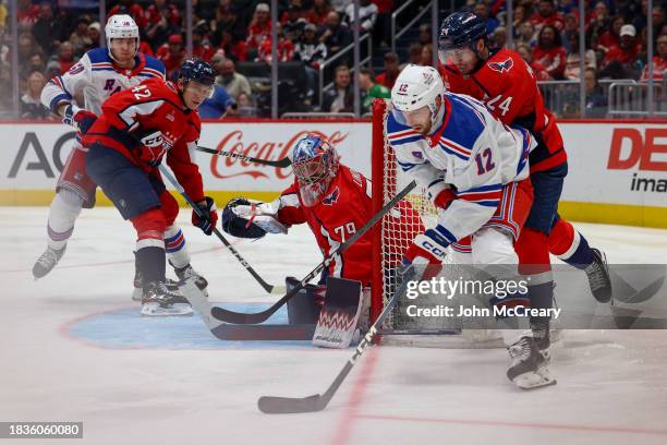 Charlie Lindgren of the Washington Capitals watches Nick Bonino of the New York Rangers as he carries the puck during a game at Capital One Arena on...