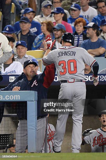 Elliot Johnson of the Atlanta Braves celebrates with manager Fredi Gonzalez after Johnson scores a run in the seventh inning against the Los Angeles...