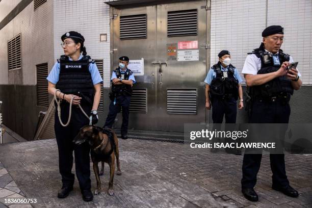 Police stand guard near a polling station for district elections in Hong Kong on December 10, 2023. Polls opened in Hong Kong's first "patriots only"...