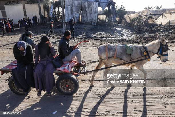 Palestinians use a donkey-pulled cart to flee Khan Yunis in southern Gaza Strip further south toward Rafah, along the Salah Al-Din road, on December...