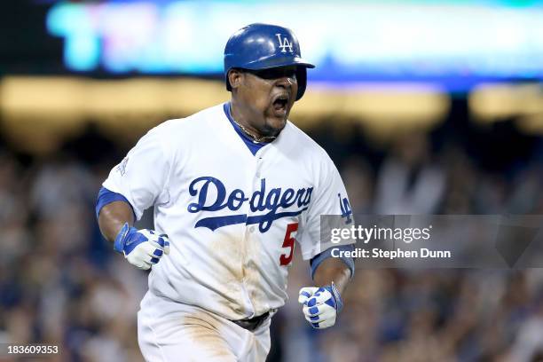 Juan Uribe of the Los Angeles Dodgers reacts after he hits a two-run home run in the eighth inning against the Atlanta Braves in Game Four of the...