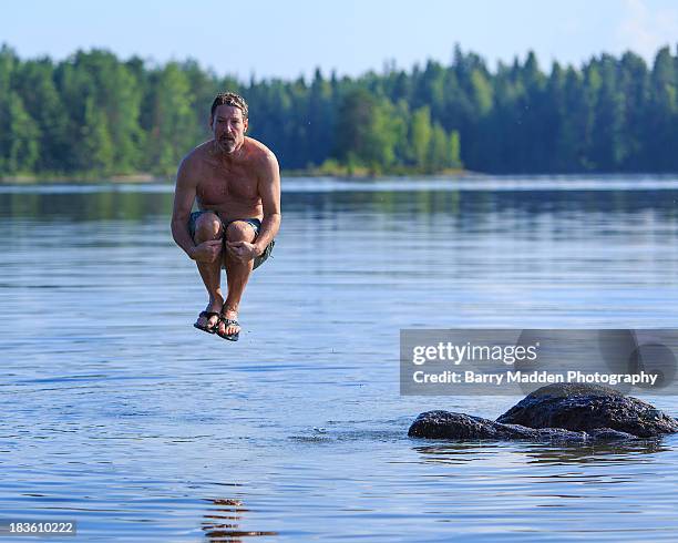 man jumping into lake - cannonball diving stock-fotos und bilder