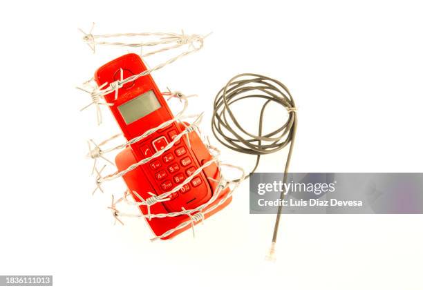 red telephone wrapped in barbed wire - telephone receiver stock pictures, royalty-free photos & images
