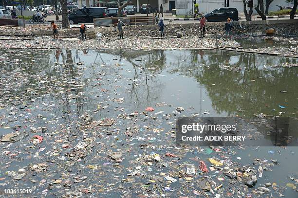 Indonesian workers clean a river in Jakarta on October 8, 2013. According to the Indonesian Environmental Status report published in June 2013 by the...