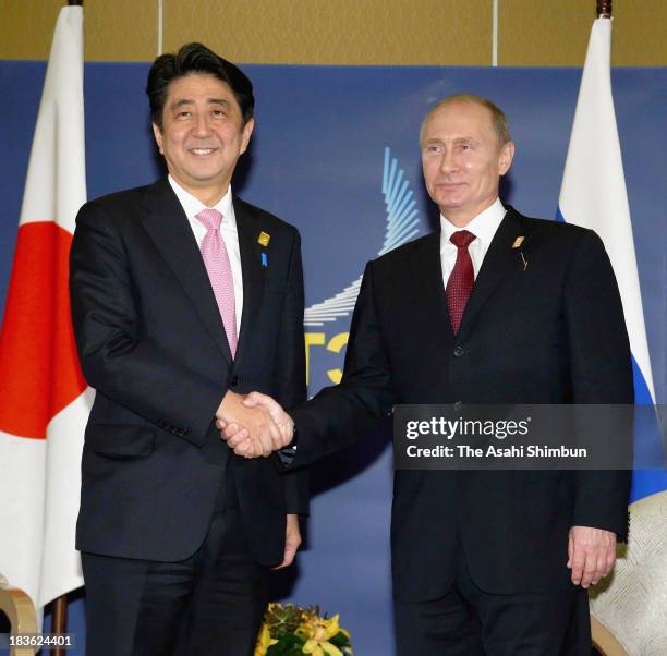 Japanese Prime Minister Shinzo Abe and Russian President Vladimir Putin shake hands during their meeting on the sidelines of the APEC summit on...