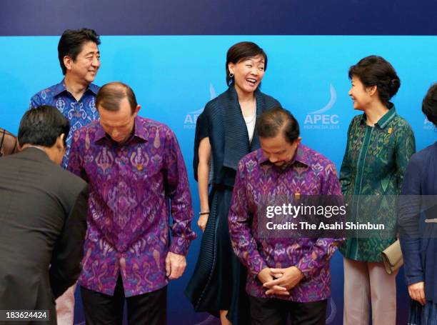 South Korean President Park Geun-hye speaks to Japanese first lady Akie Abe while Japanese Prime Minister Shinzo Abe watches at the family photo...