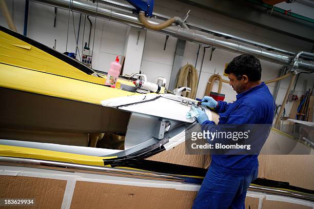 Shipwright works on a Riva Rivarama Super luxury yacht, manufactured by Ferretti Group, at the company's shipyard in Sarnico, Italy, on Monday, Oct....