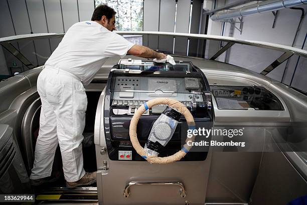 Shipwright polishes the instrument control deck onboard a part complete Riva Rivarama Super luxury yacht, manufactured by Ferretti Group, at the...