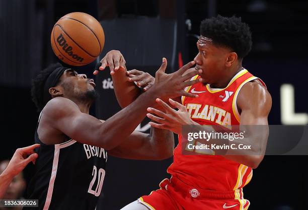 De'Andre Hunter of the Atlanta Hawks battles for the ball against Day'Ron Sharpe of the Brooklyn Nets during the first quarter at State Farm Arena on...