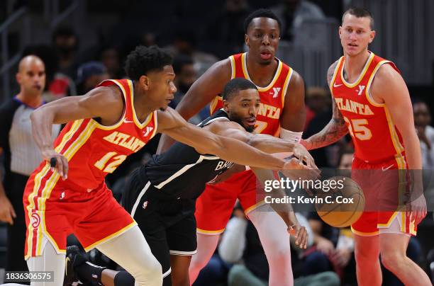 Mikal Bridges of the Brooklyn Nets draws a foul from De'Andre Hunter of the Atlanta Hawks during the first quarter at State Farm Arena on December...