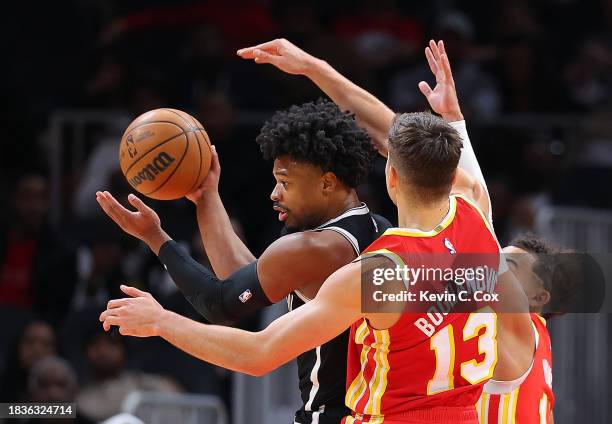 Dennis Smith Jr. #4 of the Brooklyn Nets draws a foul from Bogdan Bogdanovic of the Atlanta Hawks during the first quarter at State Farm Arena on...