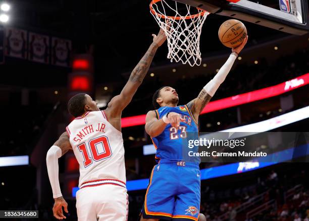 Tre Mann of the Oklahoma City Thunder drives against Jabari Smith Jr. #10 of the Houston Rockets during the first half at Toyota Center on December...