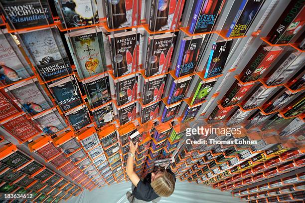 Host arranges books at the'Knaur' publishing house stand a day before the launch of the 2013 Frankfurt Book Fair on October 8, 2013 in Frankfurt,...