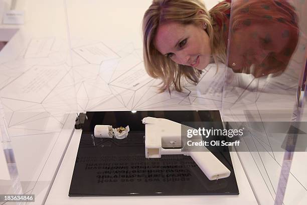 Woman admires a 3D printed handgun which was created and fired by Finnish journalist Ville Vaarne and which is displayed in the exhibition '3D:...