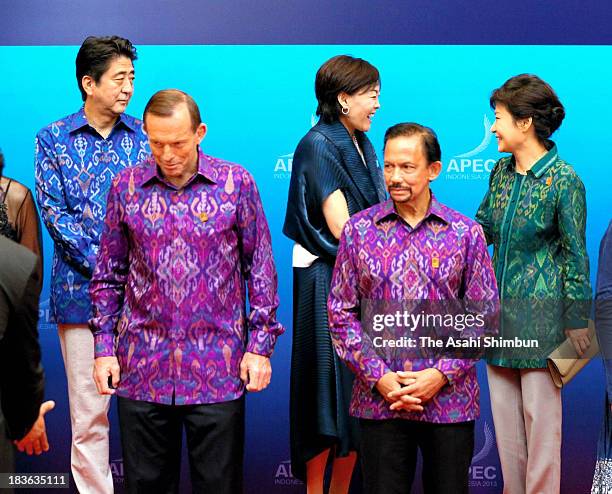 South Korean President Park Geun-hye speaks to Japanese first lady Akie Abe while Japanese Prime Minister Shinzo Abe watches at the family photo...