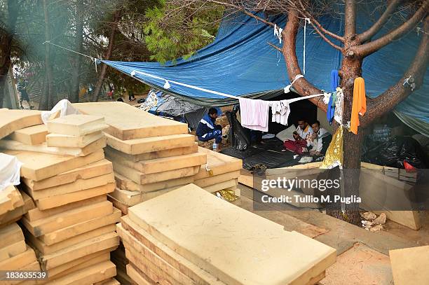 Immigrants are detained after their arrival in the temporary shelter Center on October 8, 2013 in Lampedusa, Italy. The search for bodies continues...