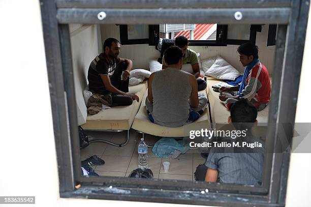 Immigrants are detained after their arrival in the temporary shelter Center on October 8, 2013 in Lampedusa, Italy. The search for bodies continues...