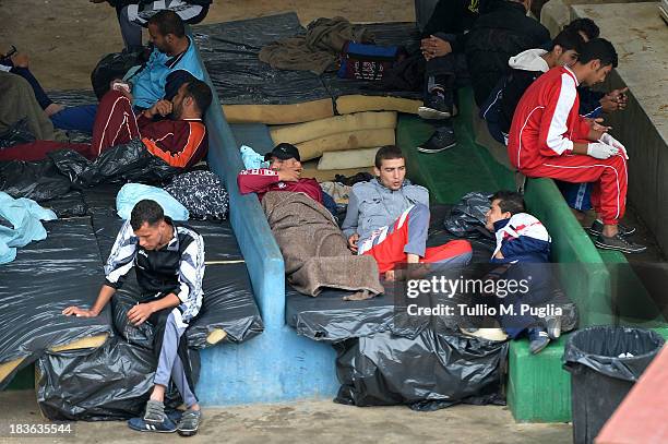 Immigrants are detained after their arrival in the temporary shelter Center on October 8, 2013 in Lampedusa, Italy. The search for bodies continues...