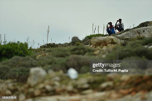 Immigrants are seen outside of the temporary shelter Center where they are detained after their arrival on the island on October 8, 2013 in...