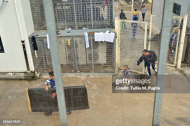 Immigrants are detained after their arrival in the temporary shelter Center on October 8, 2013 in Lampedusa, Italy. The search for bodies continues...