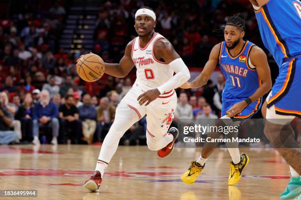 Aaron Holiday of the Houston Rockets controls the ball ahead of Isaiah Joe of the Oklahoma City Thunder during the second half at Toyota Center on...