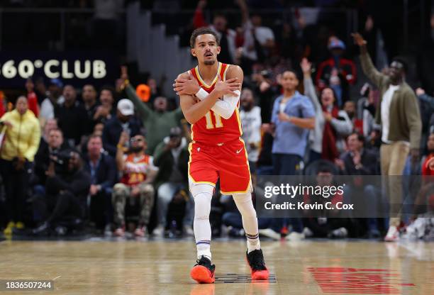 Trae Young of the Atlanta Hawks reacts after a three-point basket against the Brooklyn Nets during the fourth quarter at State Farm Arena on December...