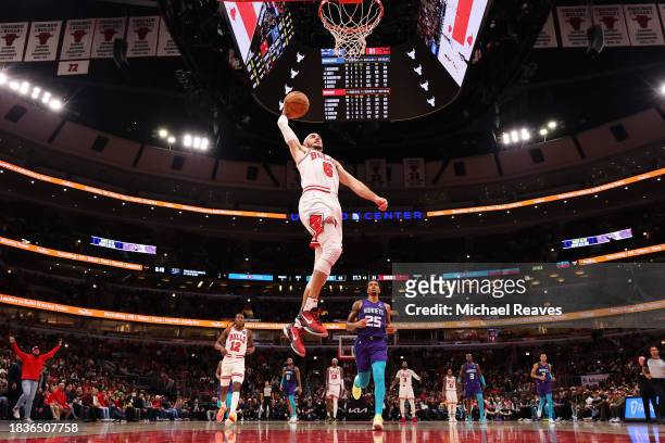 Alex Caruso of the Chicago Bulls dunks the ball against the Charlotte Hornets during the second half at the United Center on December 06, 2023 in...