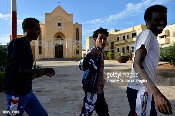 Survivors of the shipwreck off the Italian coast walk in the street of Lampedusa on October 8, 2013 in Lampedusa, Italy. The search for bodies...