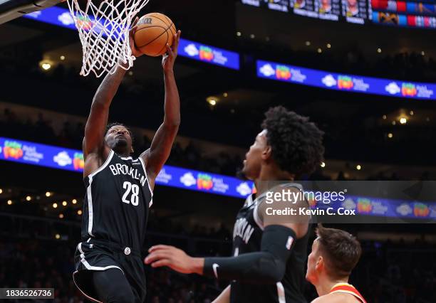 Dorian Finney-Smith of the Brooklyn Nets dunks an alley-oop from Dennis Smith Jr. #4 against Bogdan Bogdanovic of the Atlanta Hawks during the fourth...