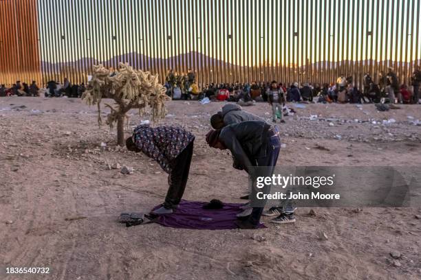Immigrants from Senegal take part in a Muslim prayer at sunset while waiting with other migrants to be transported from the U.S.-Mexico border on...