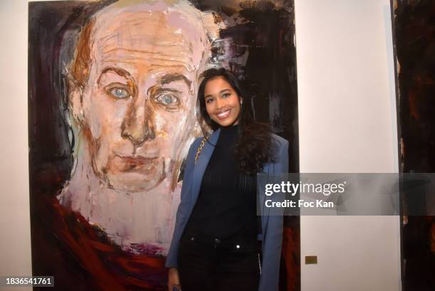 Miss France 2020 Clemence Botino poses with a portrait of Vladimir Cosma during "Immortels" Petra Marianne Marian's preview at Romanian Cultural...