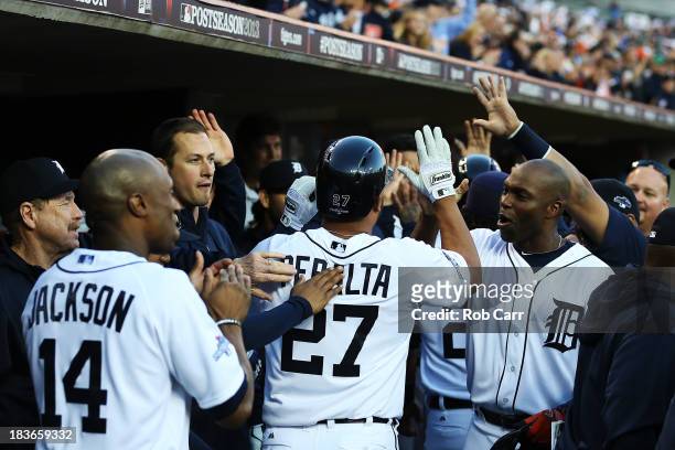 Jhonny Peralta of the Detroit Tigers celebrates with teammates in the dugout after hitting a three run home run in the fifth inning against the...