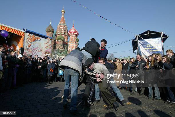 Russian men wrestle in Red Square, with St. Basil Cathedral in the background, during Maslenitsa, or Shrovetide, festivities March 8, 2003 in Moscow....