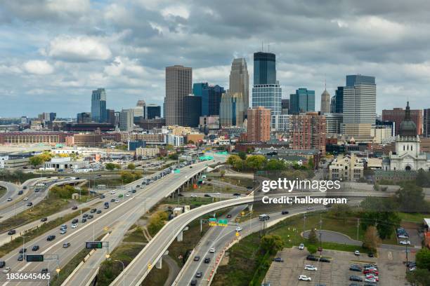 drone shot of interchange of i-94 and i-394 with downtown minneapolis skyline beyond - minneapolis aerial stock pictures, royalty-free photos & images