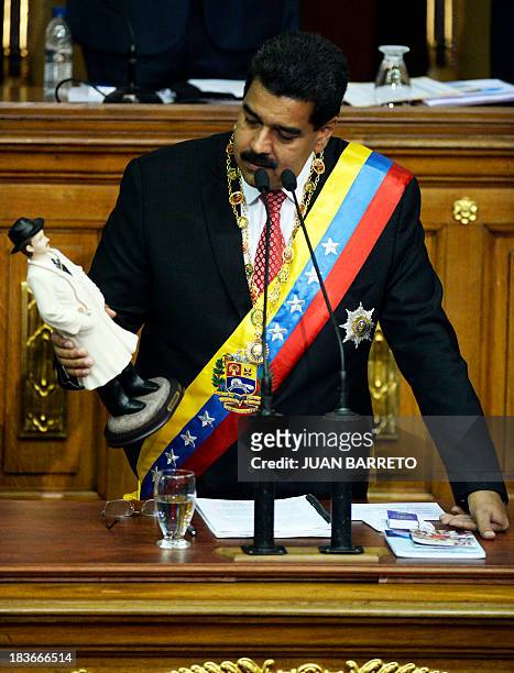 Venezuelan President Nicolas Maduro holds a statuette of Venezuelan medical doctor Jose Gregorio Hernandez at the National Assembly, in Caracas on...