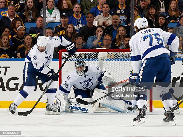 Radko Gudas of the Tampa Bay Lightning looks to clear the puck alongside teammates Ben Bishop and Pierre-Cedric Labrie in their game against the...