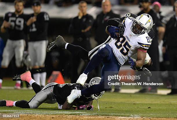 Antonio Gates of the San Diego Chargers gets tackled by Kevin Burnett of the Oakland Raiders during the fourth quarter at O.co Coliseum on October 6,...