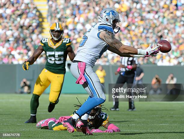 Tony Scheffler of the Detroit Lions drops a pass on third down in front of Davon House and Andy Mulumba of the Green Bay Packers at Lambeau Field on...