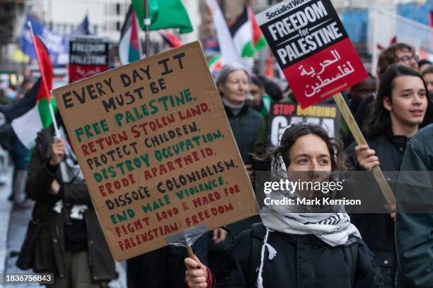 Pro-Palestinian activists take part in a National March for Palestine to call for a permanent ceasefire in Gaza on 9th December 2023 in London,...