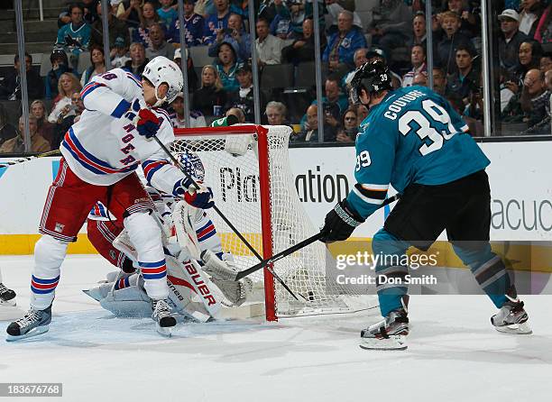 Logan Couture of the San Jose Sharks scores a goal against Marc Staal and Martin Biron of the New York Rangers during an NHL game on October 8, 2013...